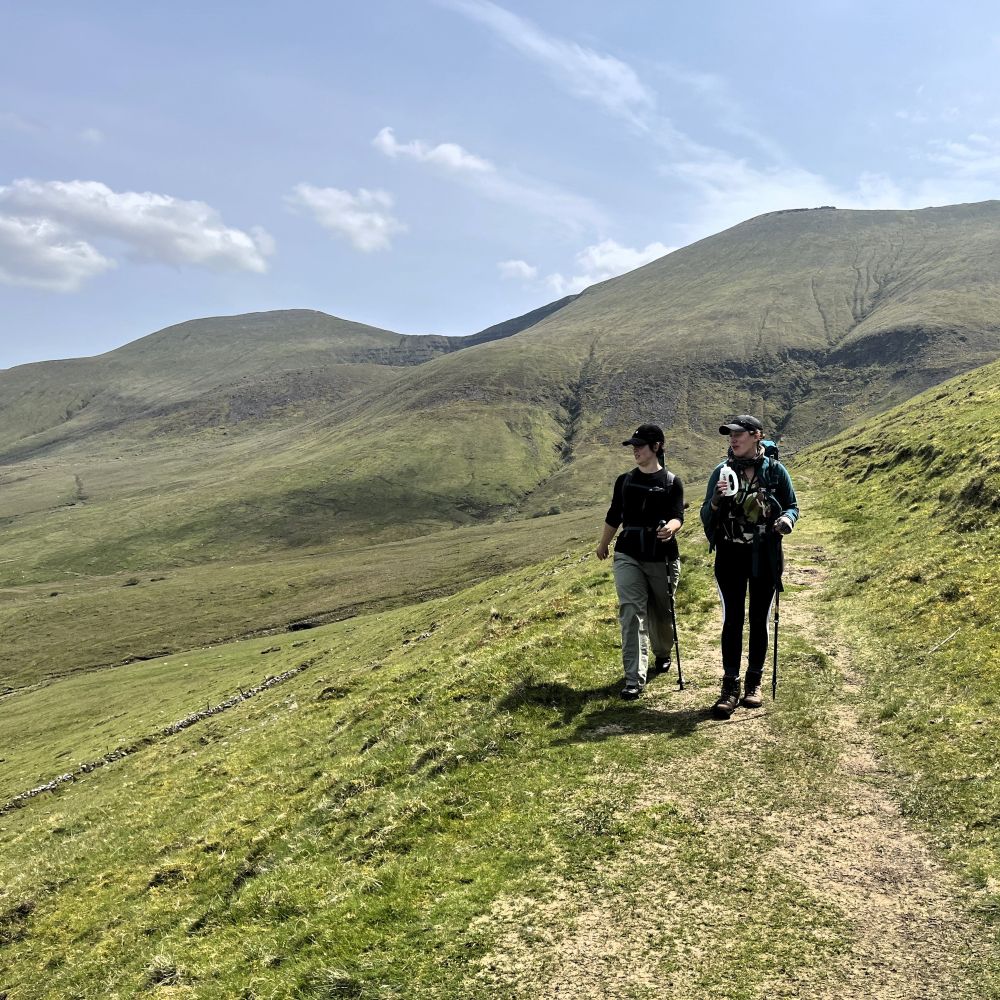 Two walkers with poles on a mountain path in the Galtee Mountains