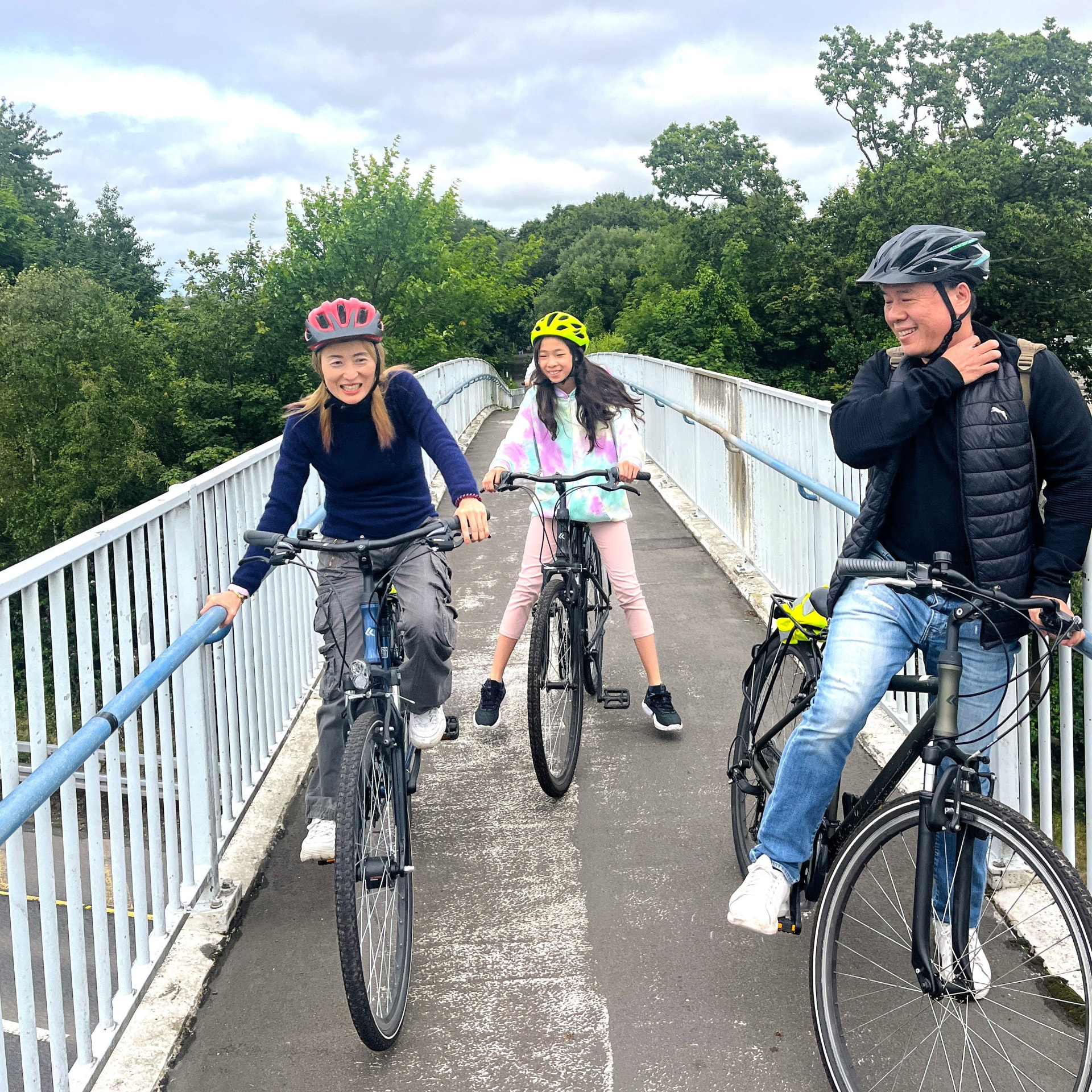 Family with bicycles pausing on a Greenway footbridge in Cork
